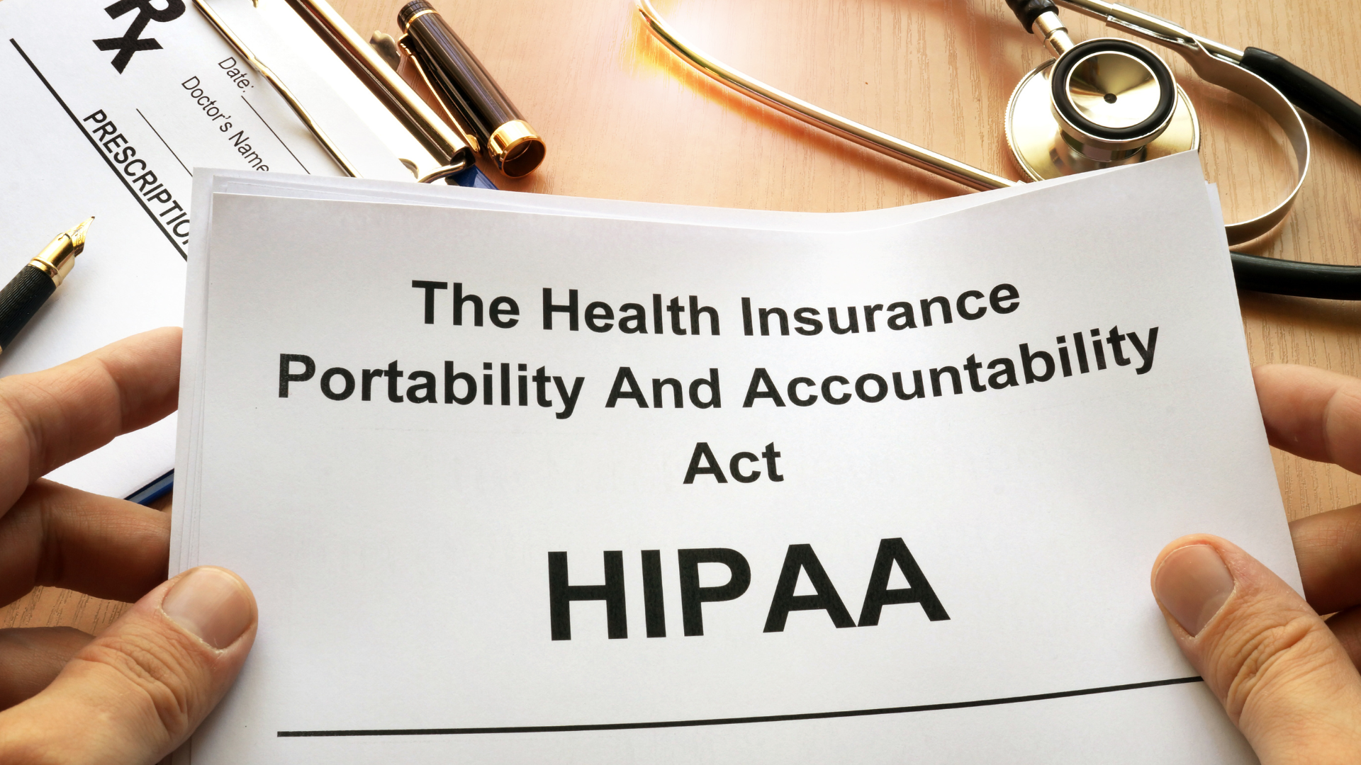 Hands holding a stack of papers that read HIPPA