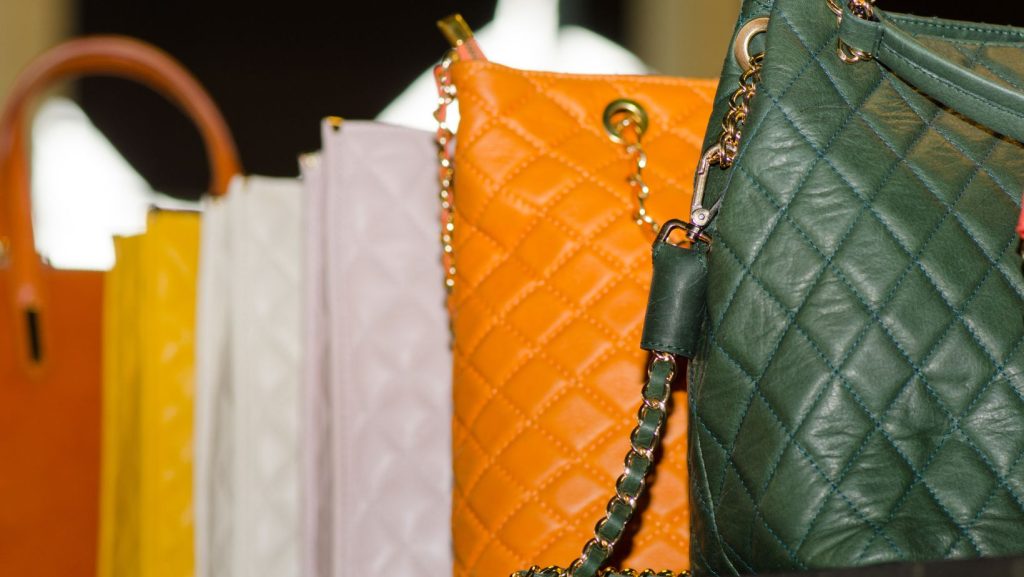 A close up of a line of handbags.