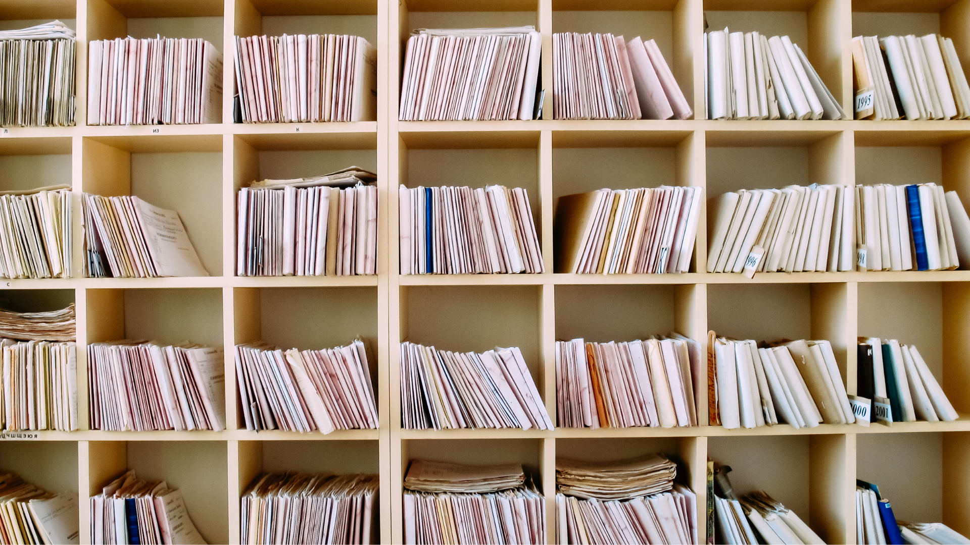 Documents and books in a wall mounted open bookshelf